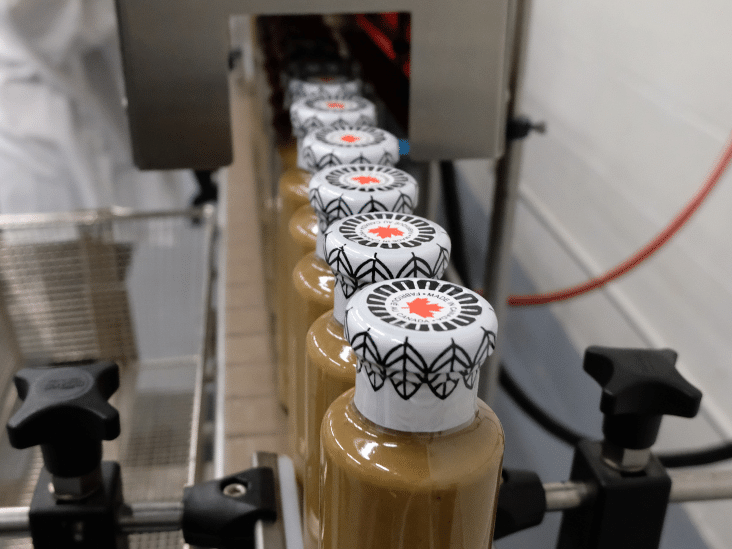 bottles of dressing on a conveyor belt