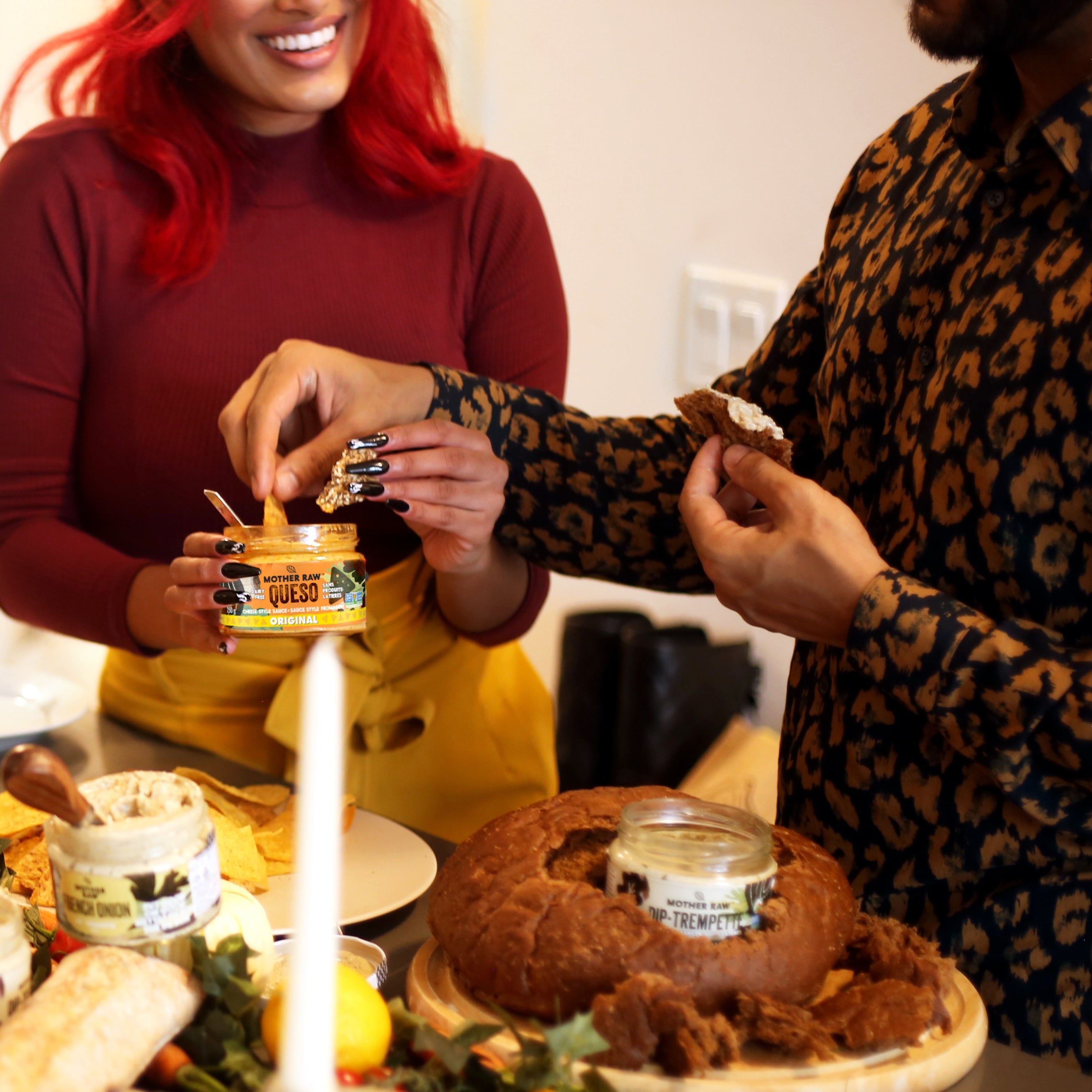 two people at a gathering enjoying a Mother Raw dip