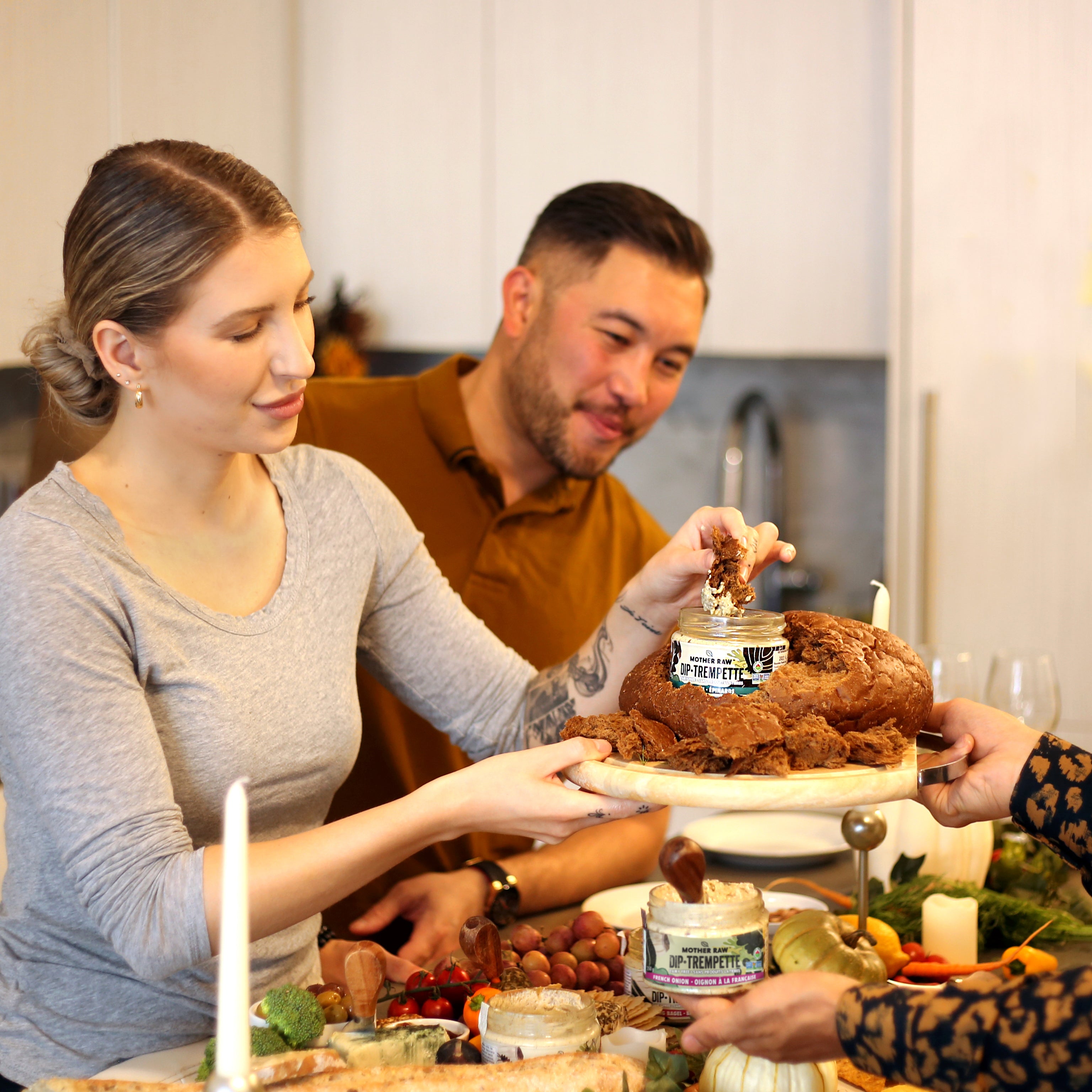 two people dipping food in a mother raw dip