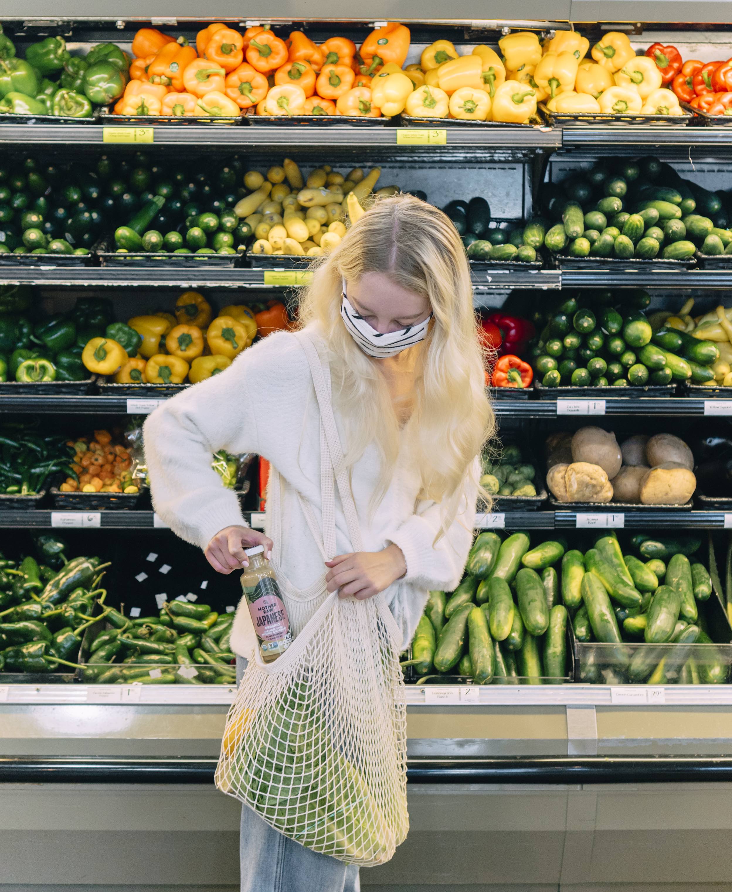 a woman putting a mother raw dressing in her grocery bag