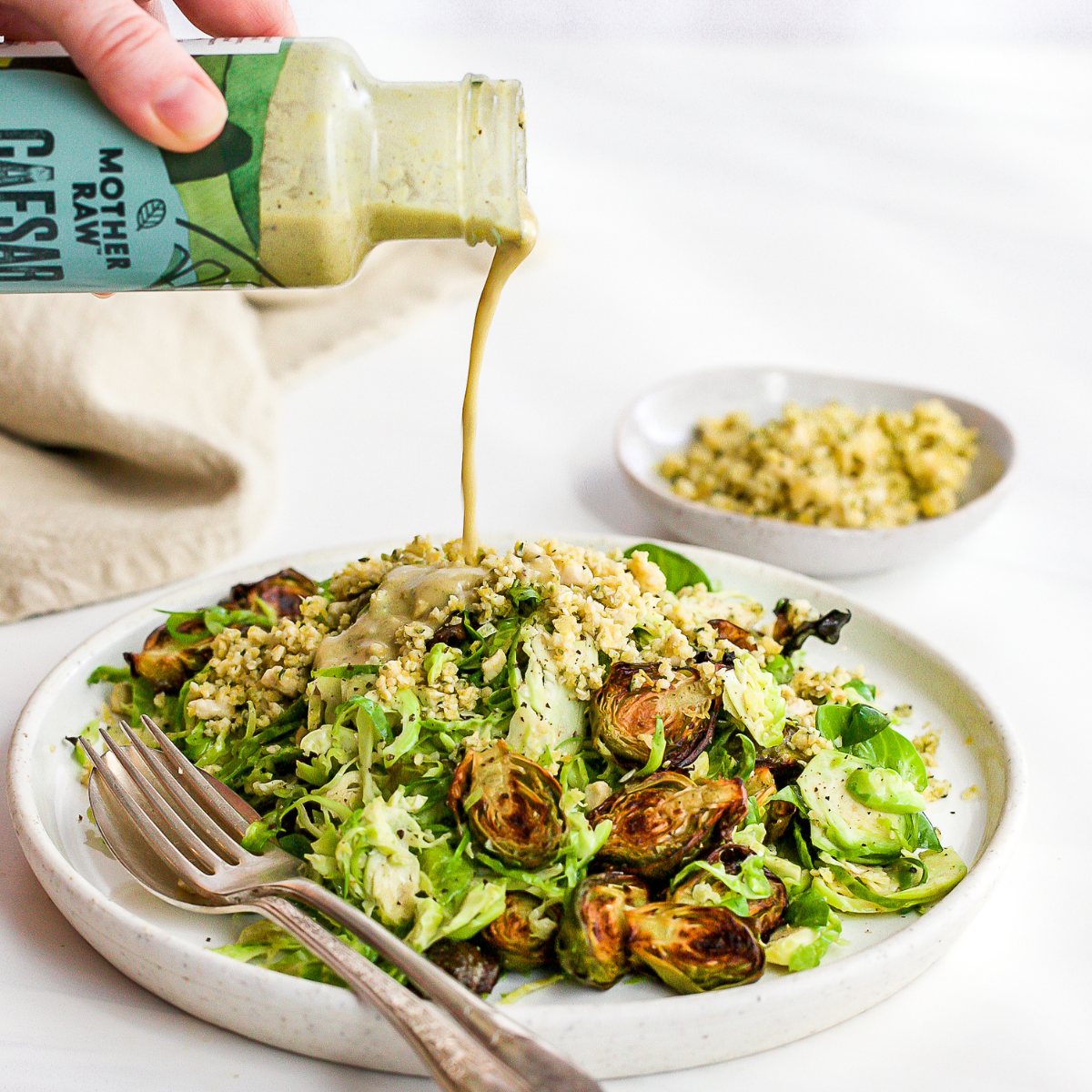 Caesar Dressing being poured on salad.