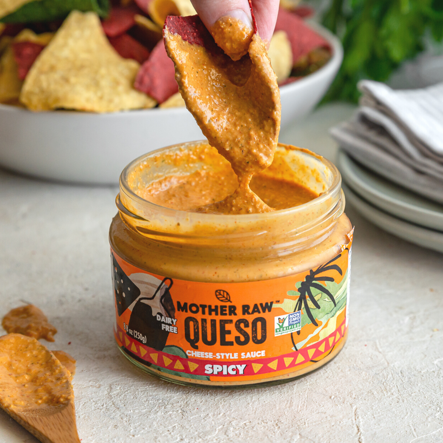 Mother Raw Dairy Free Spicy Vegan Queso Dip , Product Image dipping in cheese