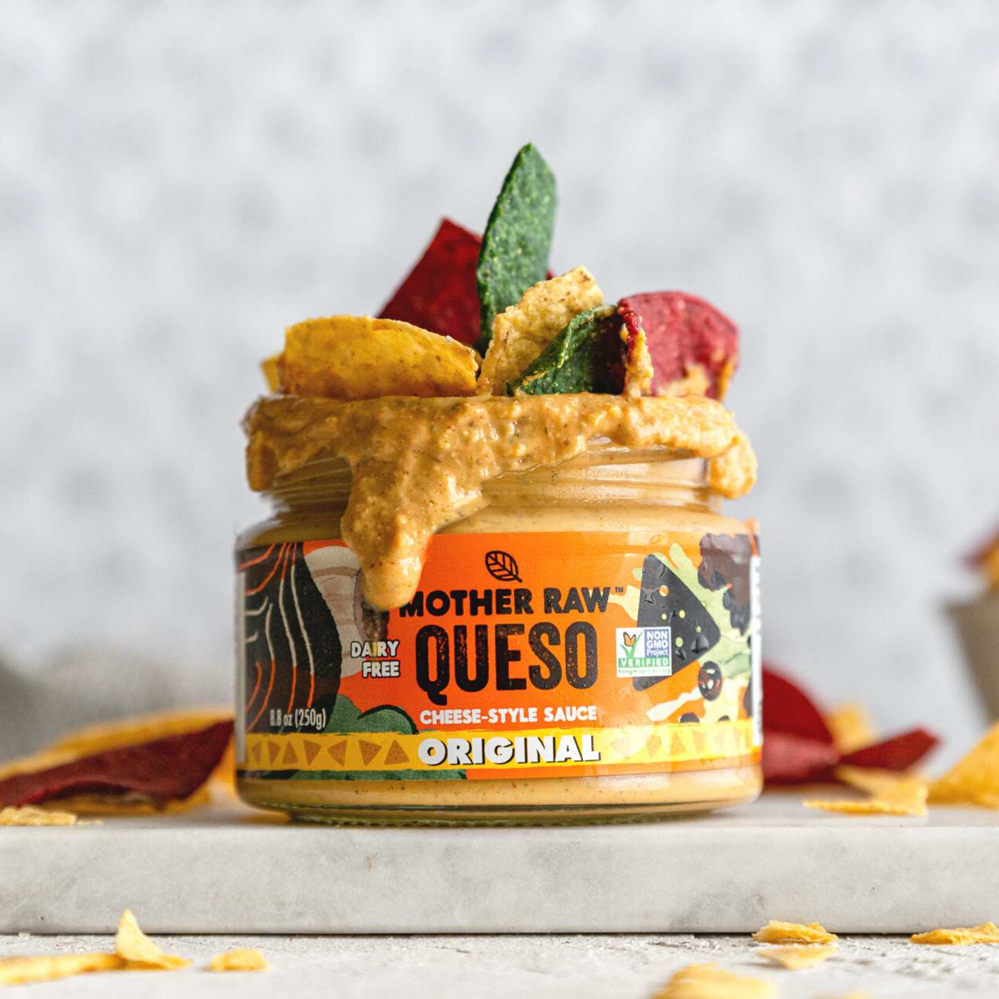 Mother Raw Vegan Diary Free Queso with tortilla chips and sauce oozing out of jar